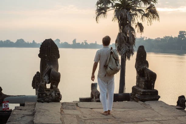 istock Young man contemplating ancient temple in Cambodia 1095664734