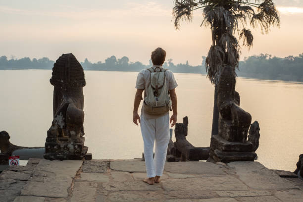 istock Young man contemplating ancient temple in Cambodia 1095664996