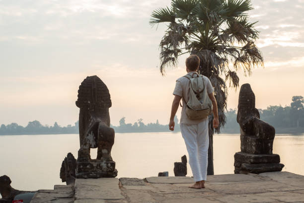 istock Young man contemplating ancient temple in Cambodia 1095667208
