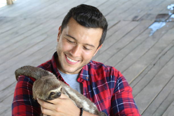 istock Tender ethnic man taking care of a sloth bear 1095669748