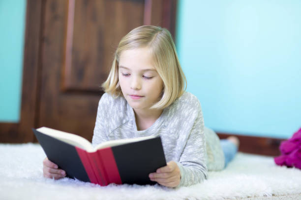 istock A blonde elementary age girl reads in her bedroom 1095672348