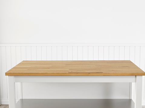 Empty table top in front of a white wall