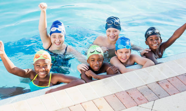 istock Multi-ethnic children on swim team in pool, cheering 1095690310