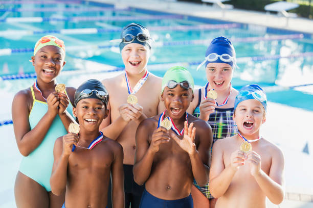 istock Multi-ethnic children on swim team holding up medals 1095692902