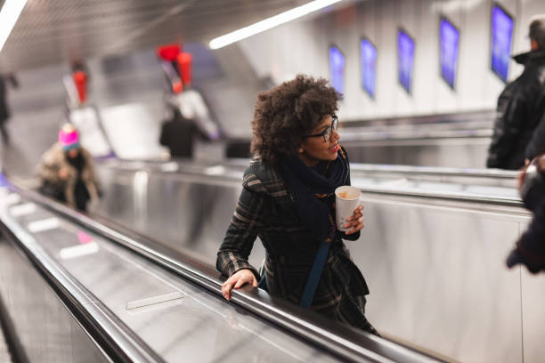 istock Beautiful young woman drinking coffee on escalator 1095694934