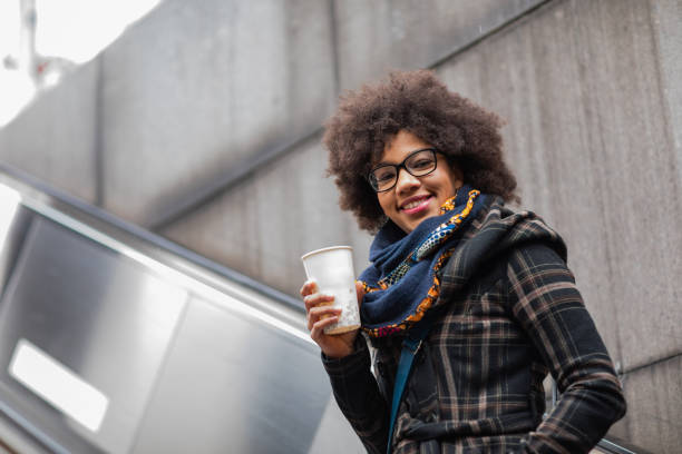 istock Beautiful young woman with coffee on  moving staircase 1095702148