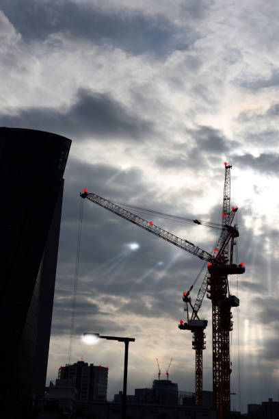 istock Crane of large construction site against the sunbeam from between cloud 1095702340