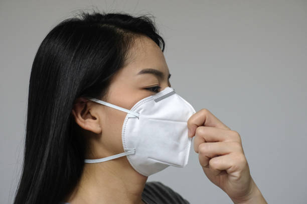 Woman wearing face mask of N95 because of air pollution in the city have particulate matters or PM 2.5. stock photo