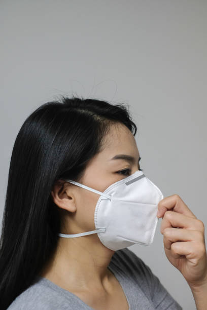 Woman wearing face mask of N95 because of air pollution in the city have particulate matters or PM 2.5. stock photo