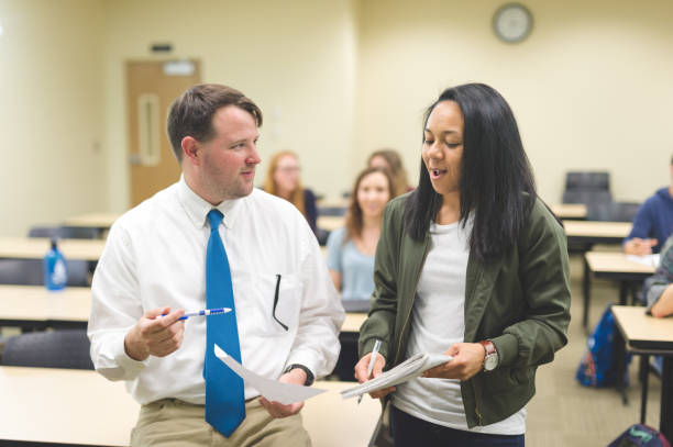 istock University teacher talking with one of his students in the classroom 1095720730