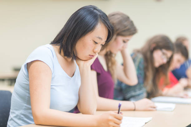 istock Female college student writing notes in a lecture hall 1095720744