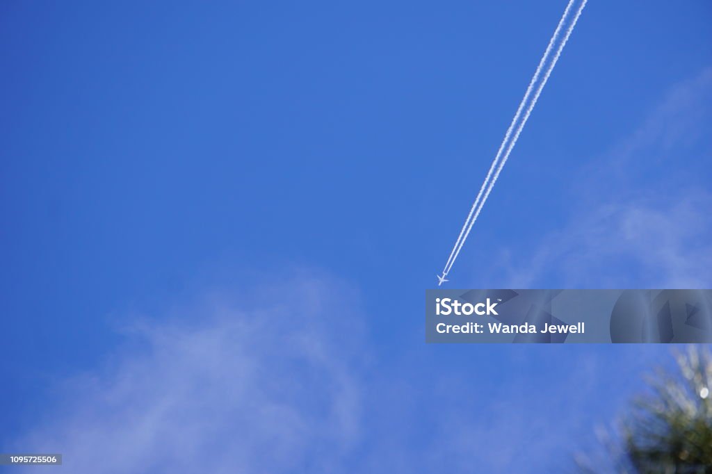 The Plane William's, Arizona sky in January with a plane flying overhead in a blue sky. 2019 Stock Photo