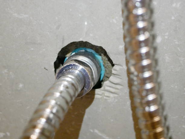 Close up of the rinsing spray hose connected to the PVC water pipe, through a metalic joint with female - male thread, as the end of the pipe is too deep inside the tiled wall - DIY ( do-it-yourself ) plumbing cerca de la manguera del rociador lavado conectada a la tubería de agua de pvc, a través de un empalme metálico con hembra - rosca macho, como el extremo de la tubería es demasiado profundo dentro de la pared de alicatado - diy (hágalo usted mismo) pl