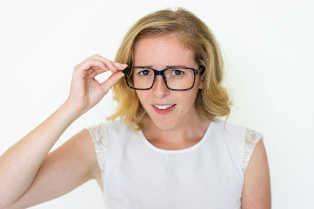 istock Attentive young woman staring at camera through glasses 1095734476