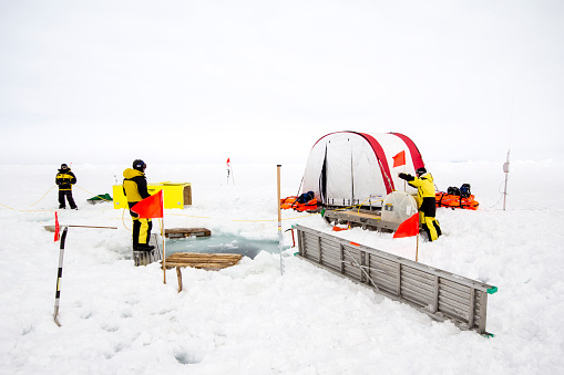 Weddell Sea, Antarctica – September 19, 2013: Scientists from a research icebreaker are establishing a remotely operated vehicle (ROV) camp over an ice floe to explore under ice algal growth