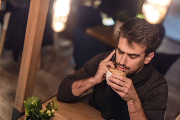 istock Serious young man having a phone conversation in coffee shop. 1095763900