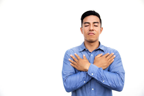 istock Hispanic young man in blue shirt is praying with closed eyes. 1095764614
