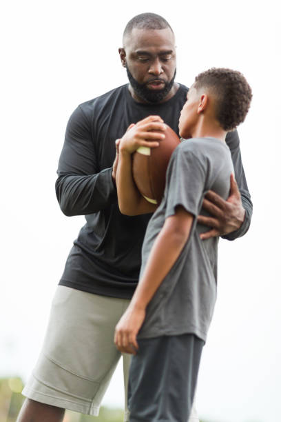 istock American Football coach training a young athlete. 1095769586
