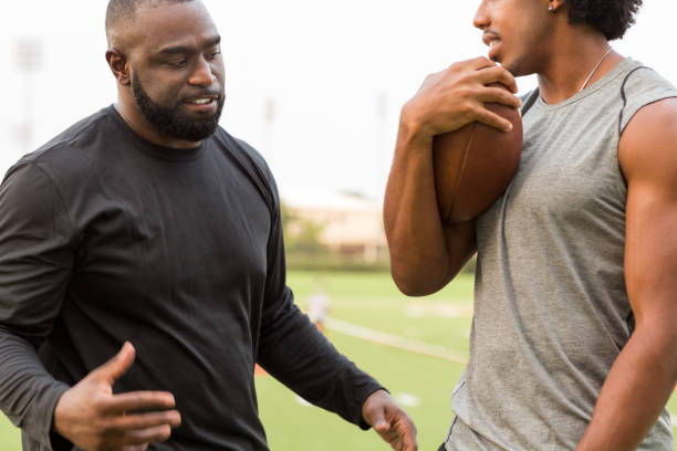 istock American Football coach training a young athlete. 1095769794
