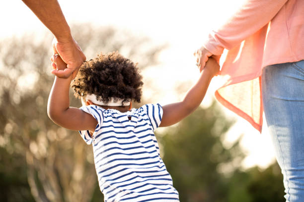 istock Little girl holding hands with her parents. 1095773644