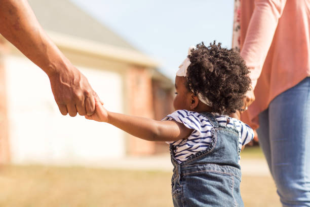 istock Little girl holding hands with her parents. 1095773744