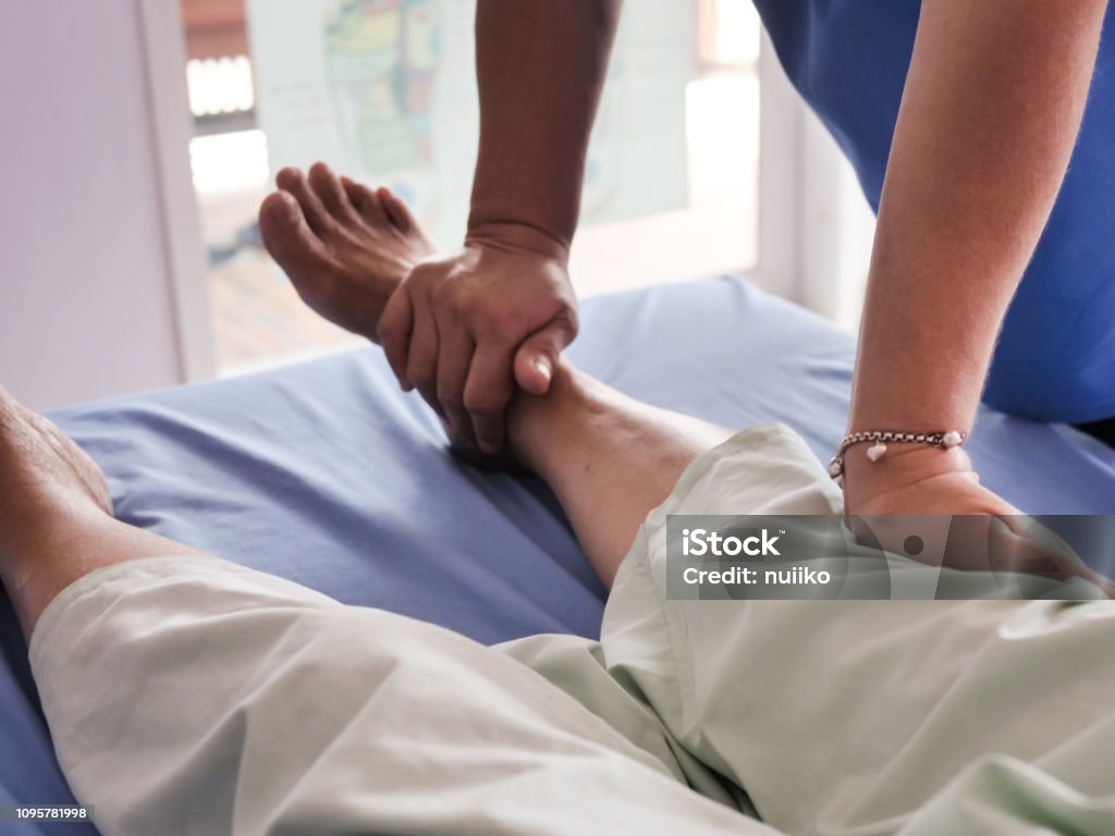 Pernas e sênior senhora tendo corpo massagem do terapeuta. - Foto de stock de Fisioterapia royalty-free
