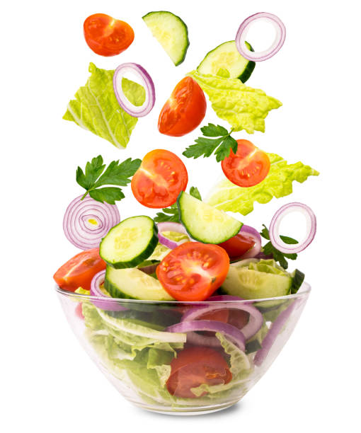 istock Fresh vegetable salad. Vegetables falling into a bowl with salad on a white, isolated. 1095784768