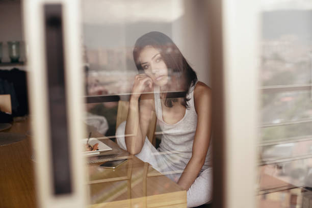Latin woman between 22-35 year old latin woman thinking in the dining room
