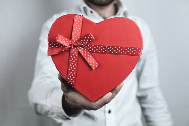 istock Man showing red heart gift. 1095808844