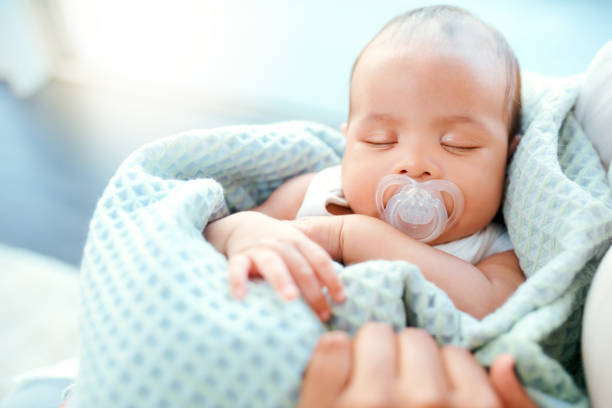 Deep in dreamland High angle shot of an adorable baby boy sleeping in his mother's arms new baby stock pictures, royalty-free photos & images