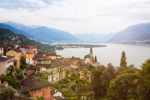 The idyllic village of Ronco sopra Ascona lies steeply on a slope above Lake Maggiore near Ascona and Locarno in Switzerland. The church is the landmark of this area. On the lake you can also see the Isole di Brissago. Beautiful panoramic view.