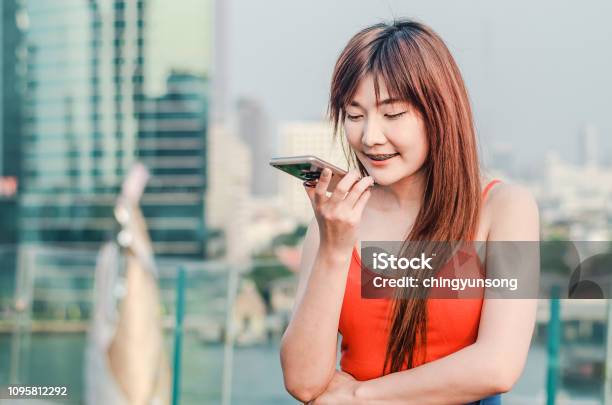 Happy Confident Woman Talking On The Mobile Cell Phone On Speakerphone Over City Background Stock Photo - Download Image Now