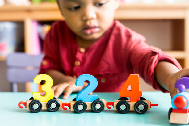 bambino che gioca a matematica giocattolo di legno all'asilo nido - child preschool toy playing foto e immagini stock