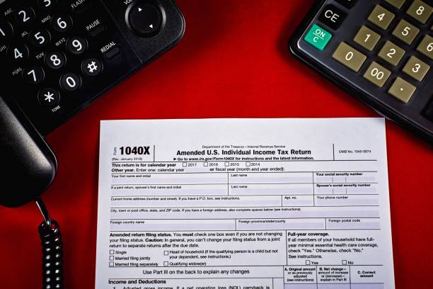 Clean Tax Form 1040X Tax Form 1040X, phone and calculator on a red velvet background, close-up IRS Headquarters Building stock pictures, royalty-free photos & images