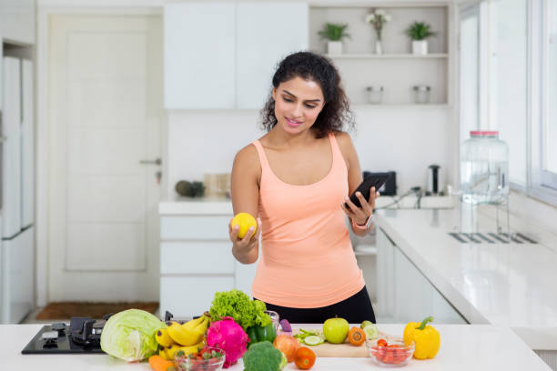 istock Pretty girl using a phone during preparing salad 1095832856