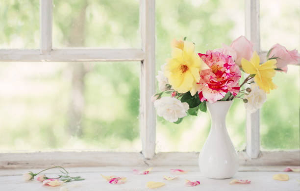 istock roses oin vase on old windowsill 1095835738