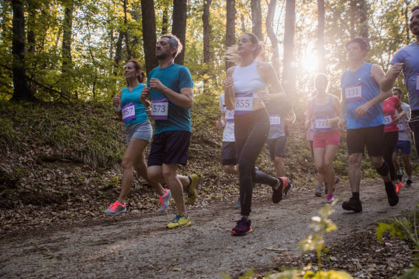 istock Large group of mixed age athletes running a marathon in nature. 1095841238