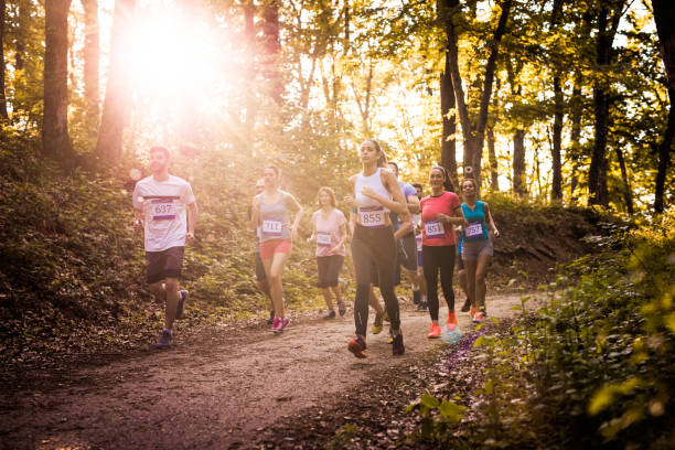 istock Group of marathon runners running on a path in the forest. 1095842916