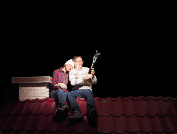 a married couple is sitting on the roof of a house at night. isolated on black. - cork tops imagens e fotografias de stock