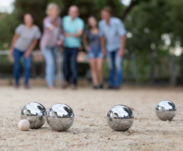 bild von menschen spielen boule auf sand - pétanque stock-fotos und bilder