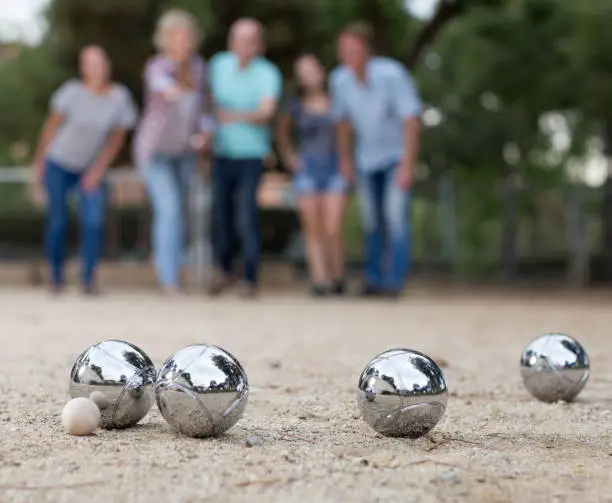 Image of people playing petanque on sand together on holidays