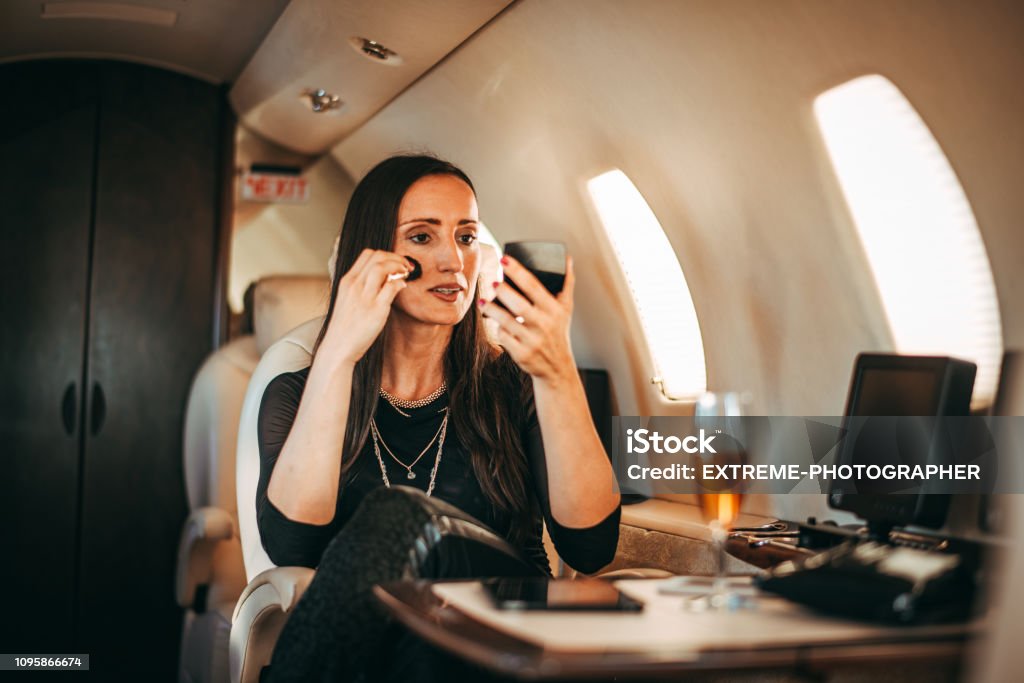 Exitosa Mujer Retocar Su Maquillaje Usando Un Espejo De Bolsillo Mientras  Viajan En Un Jet Privado Foto de stock y más banco de imágenes de Estilos  de vida - iStock