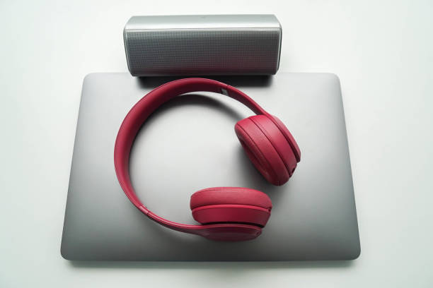 istock isolated notebook computer with cute pink wireless headphone and bluetooth speaker for listening to music during working 1095867136