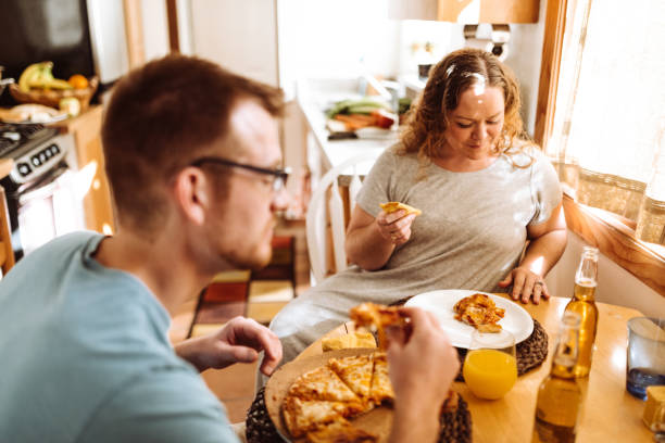 istock couple eating pizza at home 1095871618
