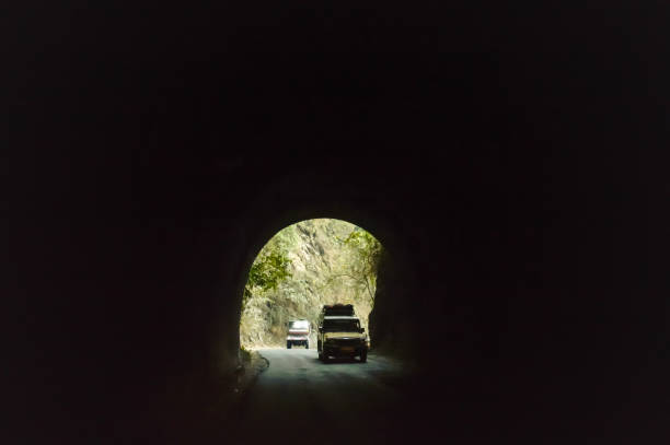 auto fährt durch die städtischen autobahntunnels. blick von schlecht beleuchteten tunnel aus einem schnell fahrenden auto an einem sonnigen tag. motion blur hintergrund. - the end approaching day people stock-fotos und bilder