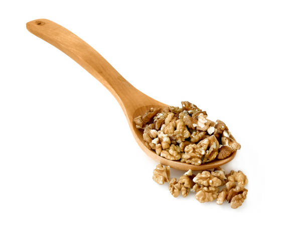 istock Walnuts in a wooden spoon over white background 1095878306