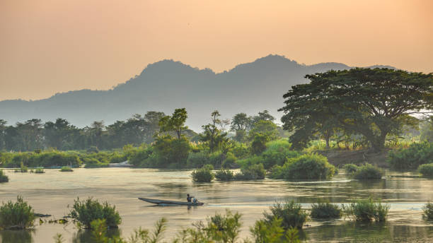 река меконг 4000 островов лаос, восход драматического неба, туман на воде, знаменитый туристический турист в юго-восточной азии - река меконг стоковые фото и изображения