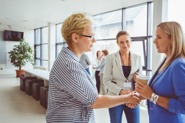 istock Women shaking hands during a break in seminar 1095887160