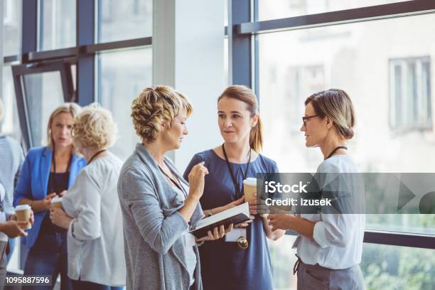 Women Talking During Coffee Break At Convention Center Stock Photo - Download Image Now