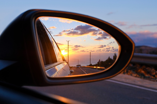 Wonderful sunset in the rearview mirror of a car